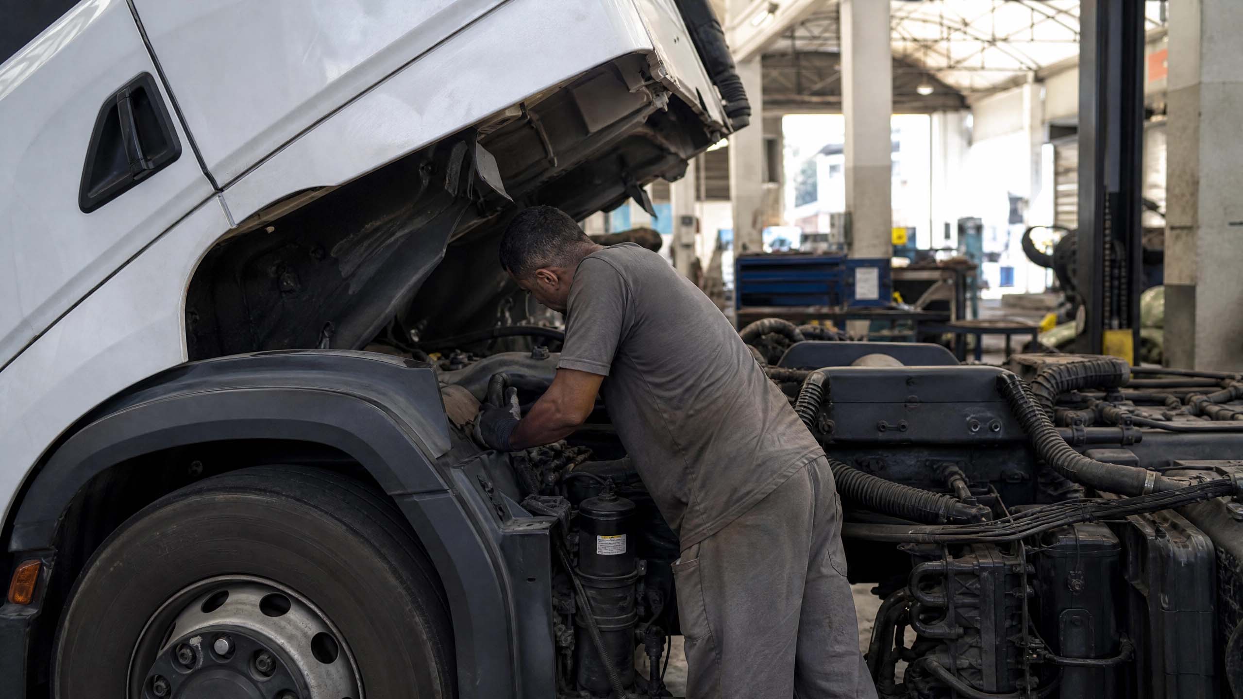 Mecânico realizando manutenção preventiva em caminhão Volkswagen em oficina