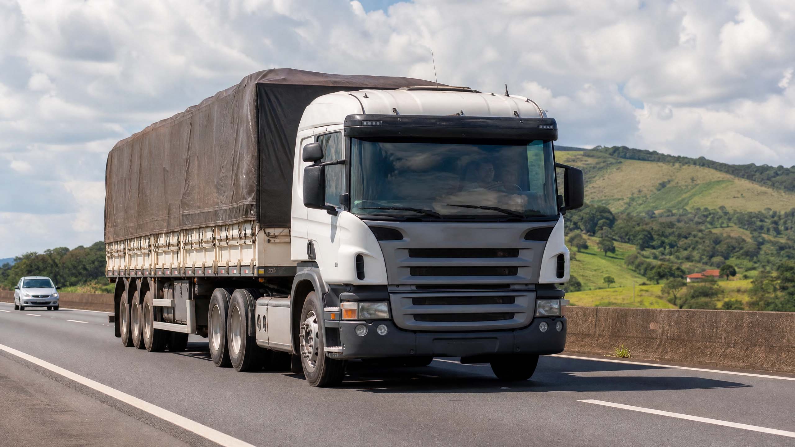 Caminhão Scania em rodovia com montanhas ao fundo
